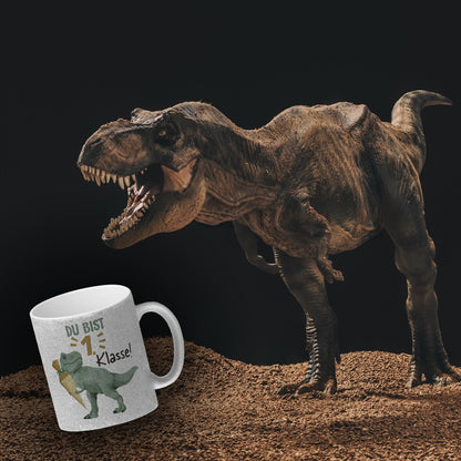 Dino mit Schultüte Glitzer-Kaffeebecher mit Spruch Du bist 1. Klasse!