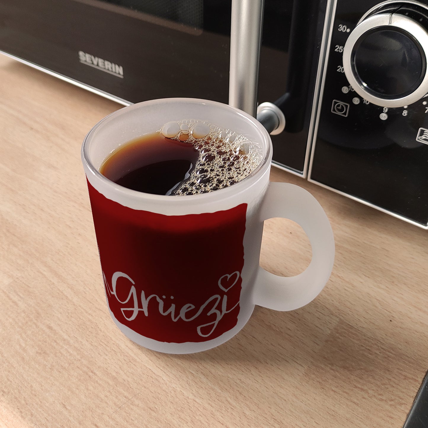 Glas Tasse mit Grüezi-Schriftzug mit Herz und Bergen