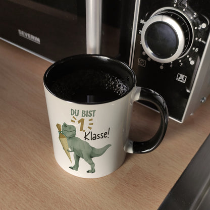 Dino mit Schultüte Kaffeebecher in schwarz mit Spruch Du bist 1. Klasse!