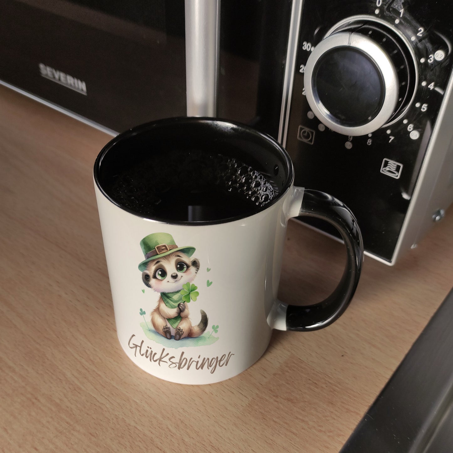 Erdmännchen Glücksbringer Kaffeebecher in schwarz