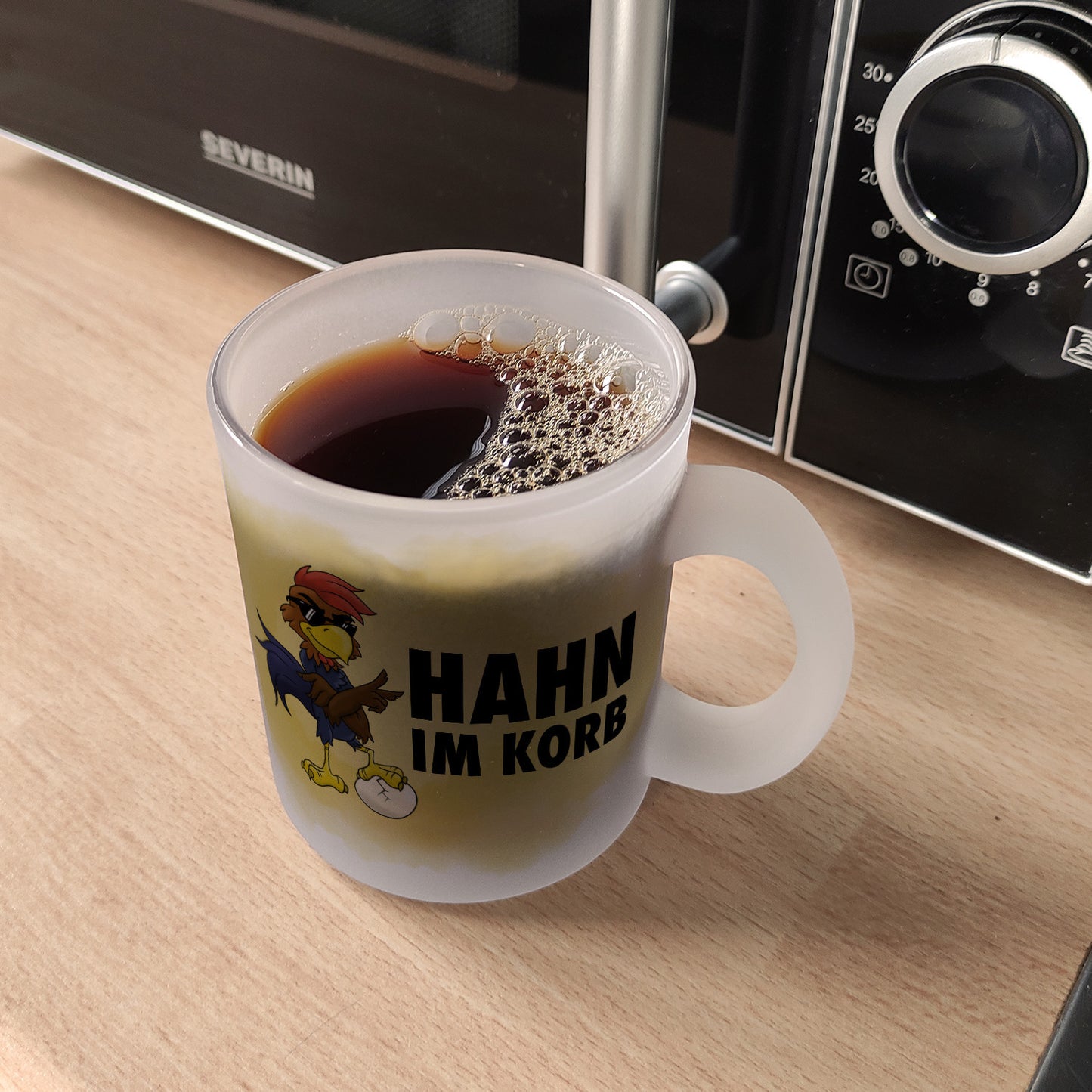 Hahn im Korb Glas Tasse Das einzigartige Cartoon-Motiv eines Hahns macht diesen Kaffeebecher zu einem echt ausgefallenem Geschenk für Kollegen, Familie und Freunde die vielleicht alleine als Hahn im Korb sitzen. mit Cartoon-Hahn, Aufschrift Motiv