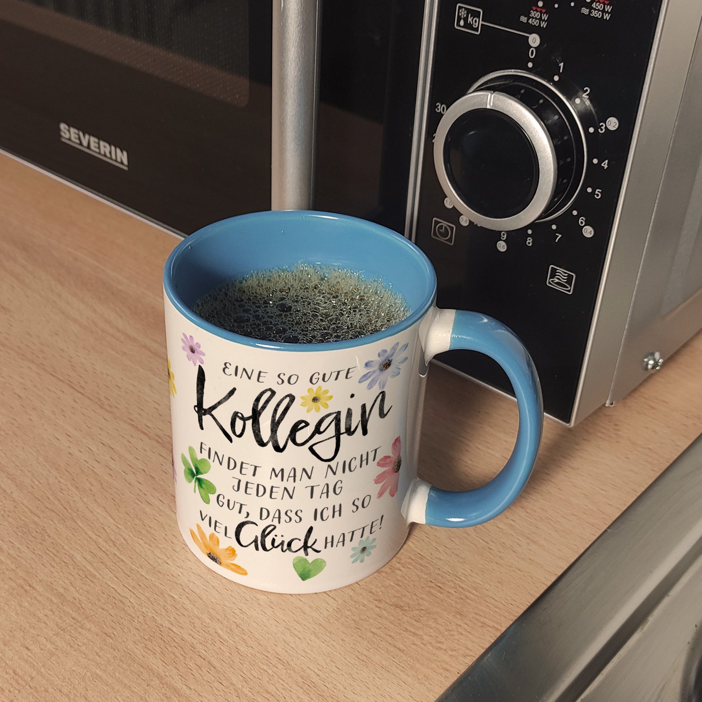 Blumen Kaffeebecher in hellblau mit Spruch Glück gehabt mit toller Kollegin