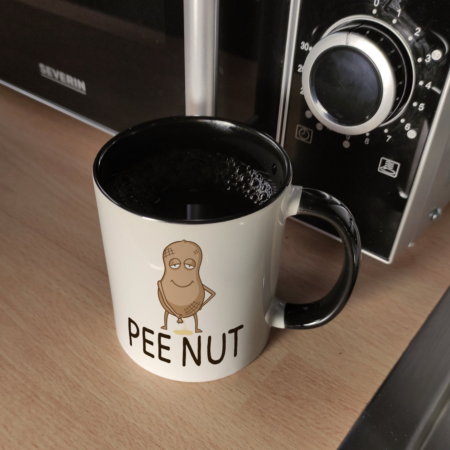 Pee nut Kaffeebecher Schwarz mit pinkelnder Erdnuss