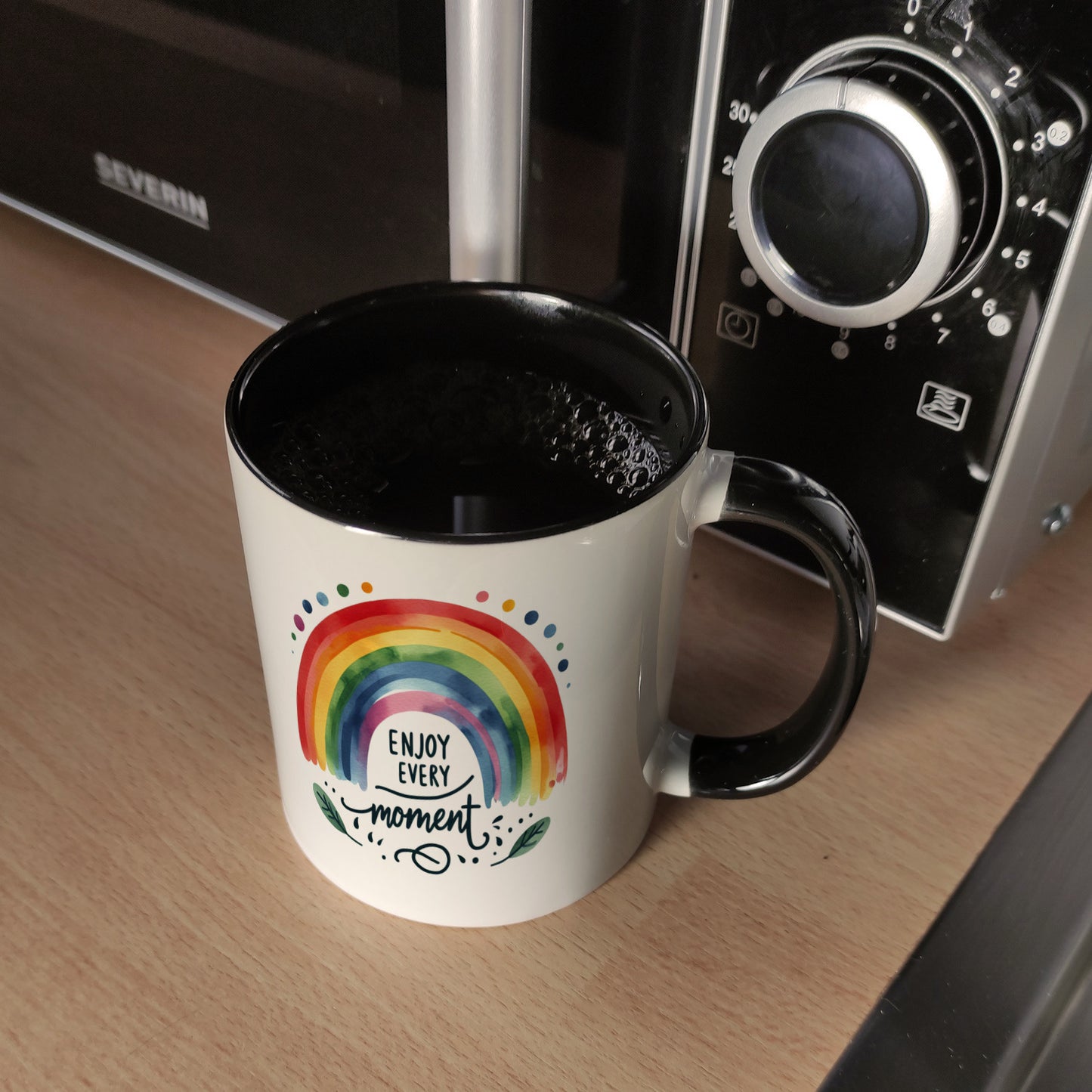 Regenbogen Kaffeebecher in schwarz mit Spruch Enjoy every moment