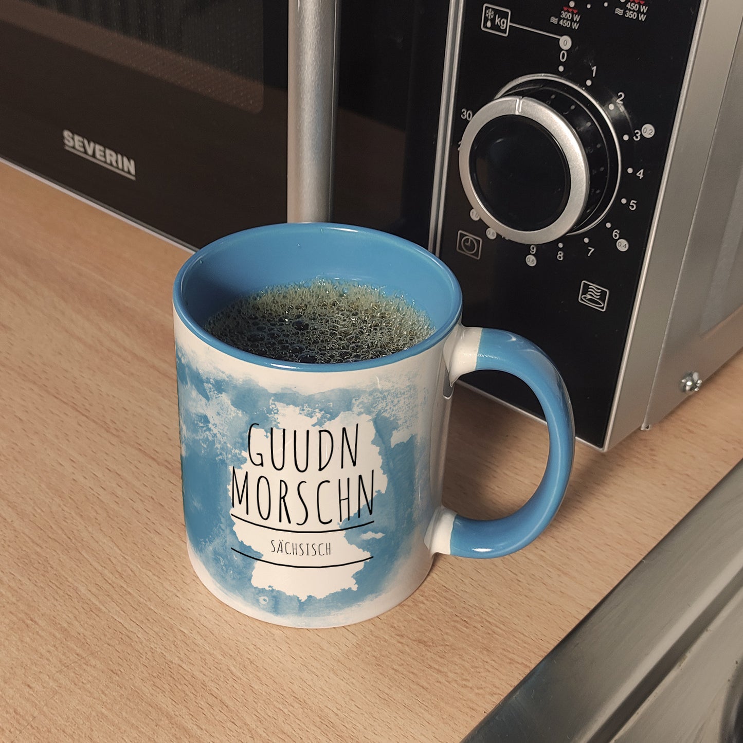 Hallo auf Sächsisch Guudn Morschen lustiger Kaffeebecher Hellblau mit blauem Hintergrund