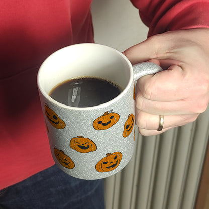 Glitzer-Kaffeebecher im Halloween Design - mit vielen lustigen geschnitzten Kürbisköpfen